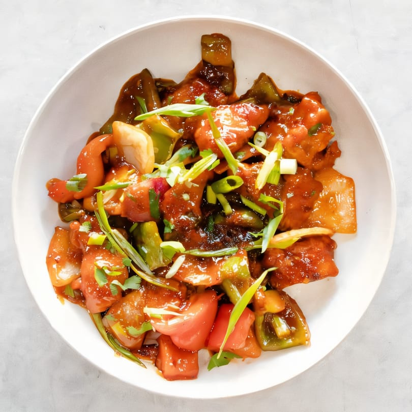 Chilli Chicken from Saffron Indian Cuisine, a vibrant dish with chicken, peppers, and onions in a rich sauce.